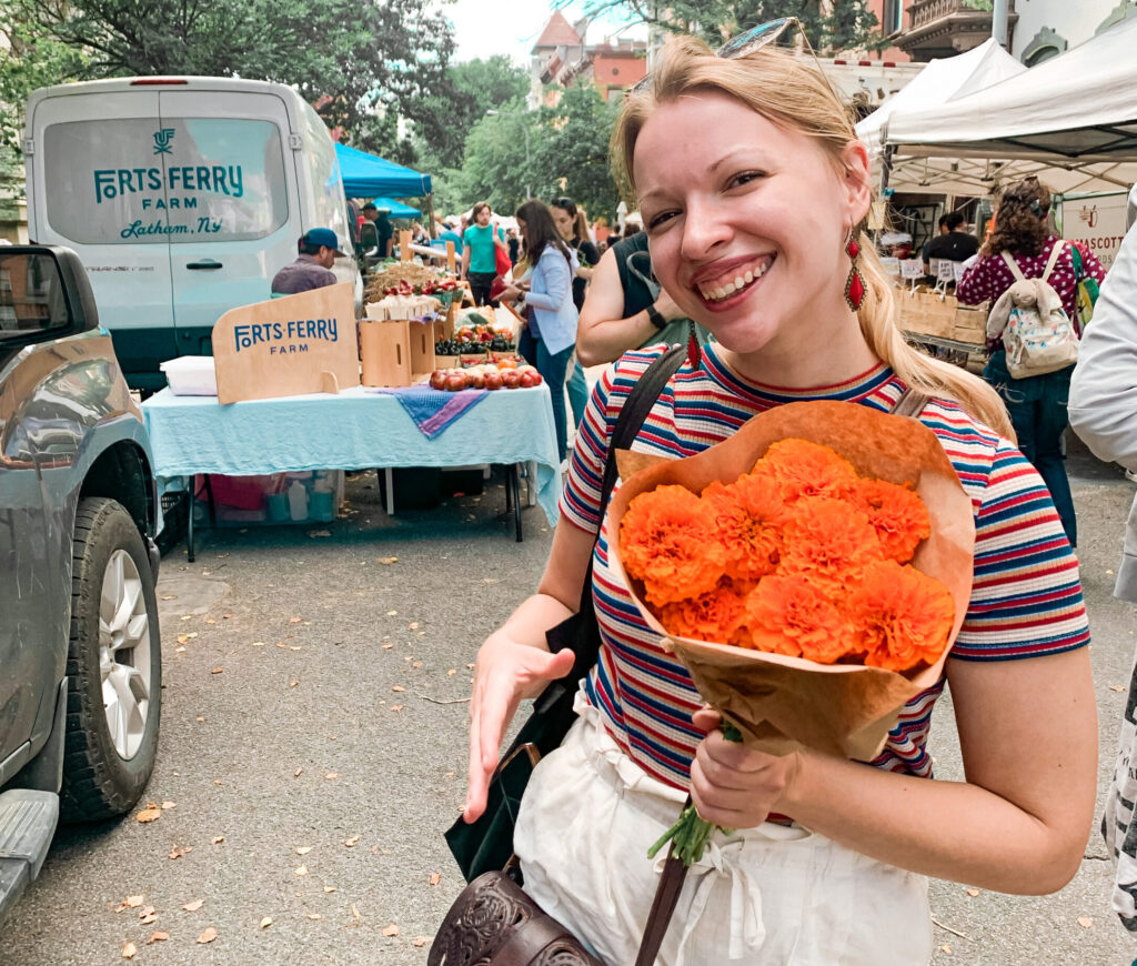 girl holding flowers at a farmers market