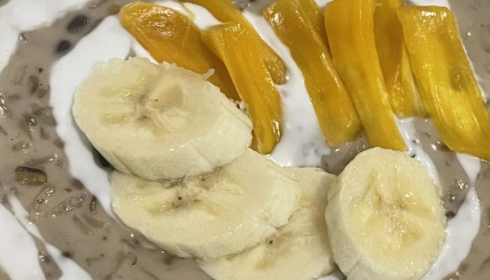 finished mung bean pudding with banana slices, coconut drizzle, and yellow fruit slices.