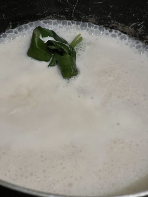 simmering coconut milk in a pot.