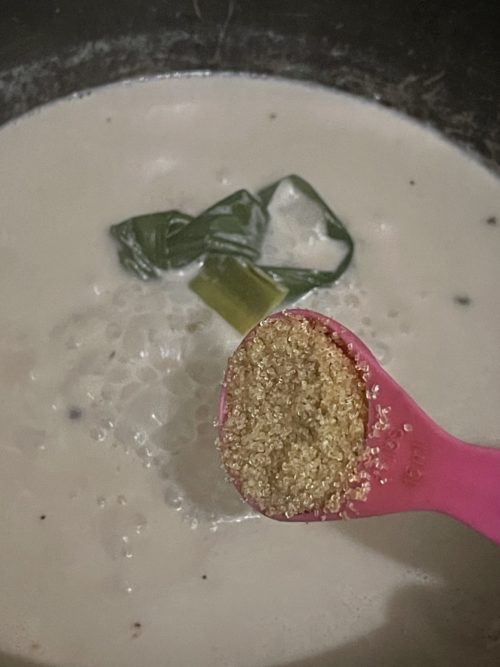 pink spoon that's stirring in sugar into coconut milk mixture.