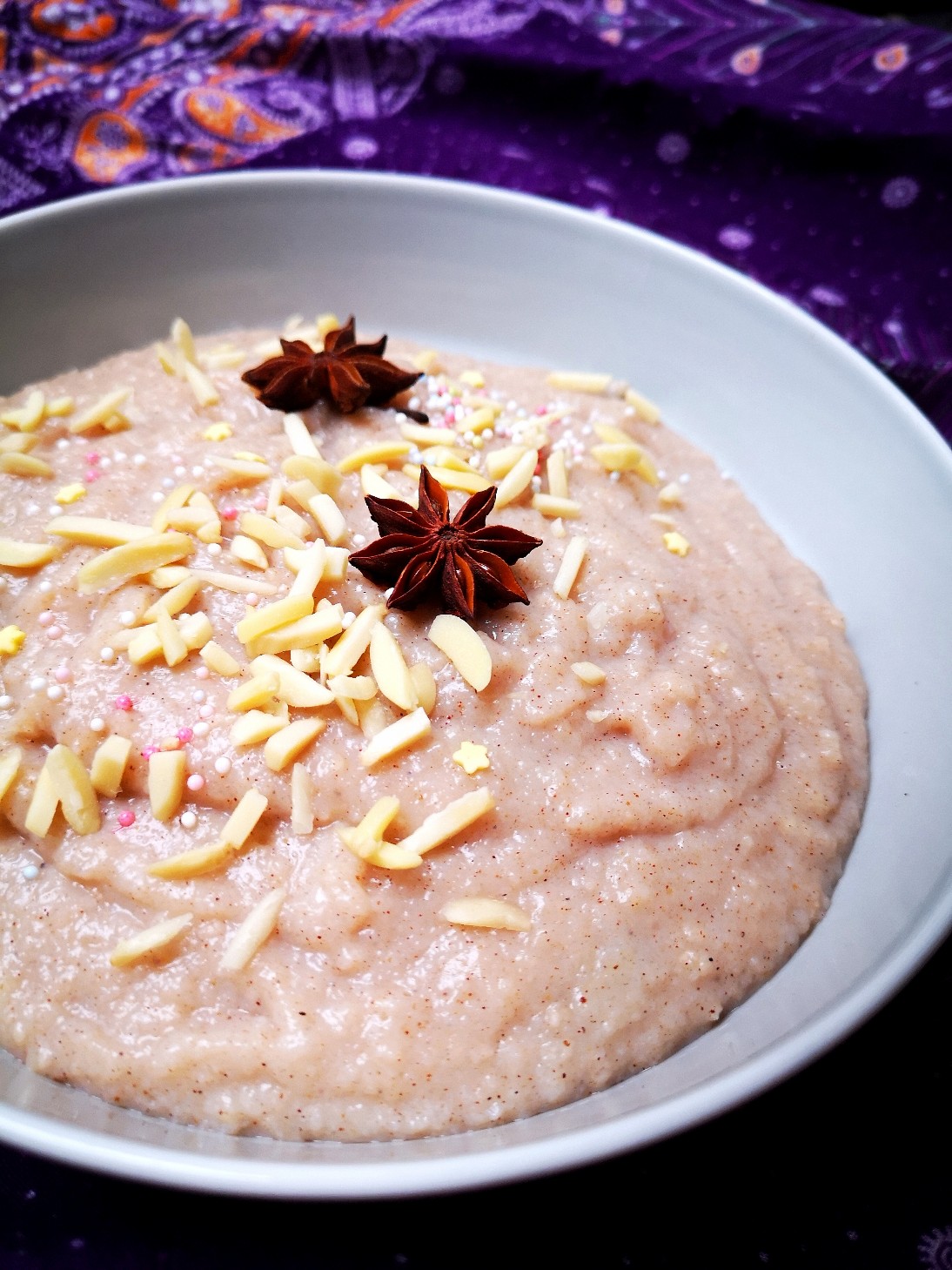 Rice porridge in a white bowl against a purple background