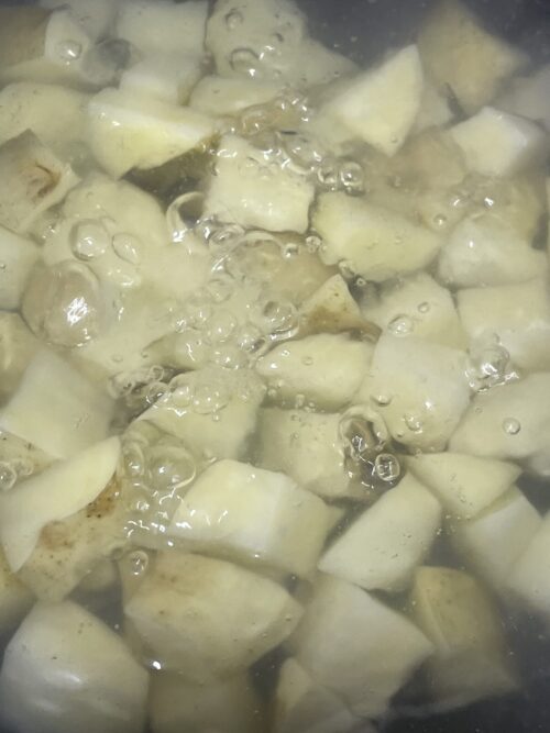 boiling potato cubes in water.
