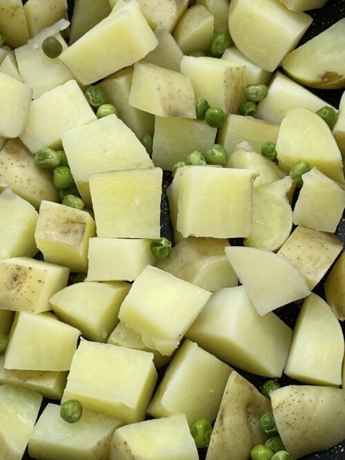 potatoes cubed and boiled with peas, then drained.