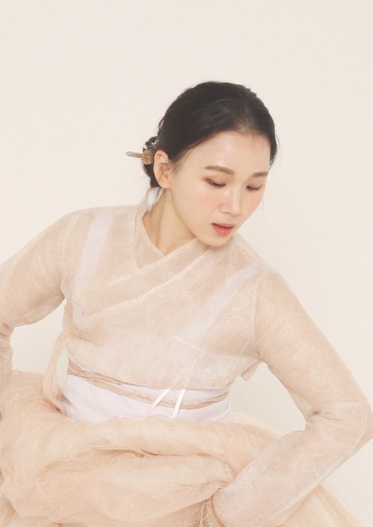 a beautiful korean woman in translucent hanbok against a light beige background. 