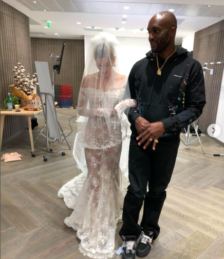 Hailey Bieber walking arm in arm with Virgil Abloh, the designer of her wedding dress.