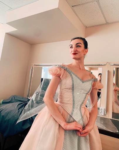 Joy Womack in a pink bodice and romantic tutu in a dressing room.