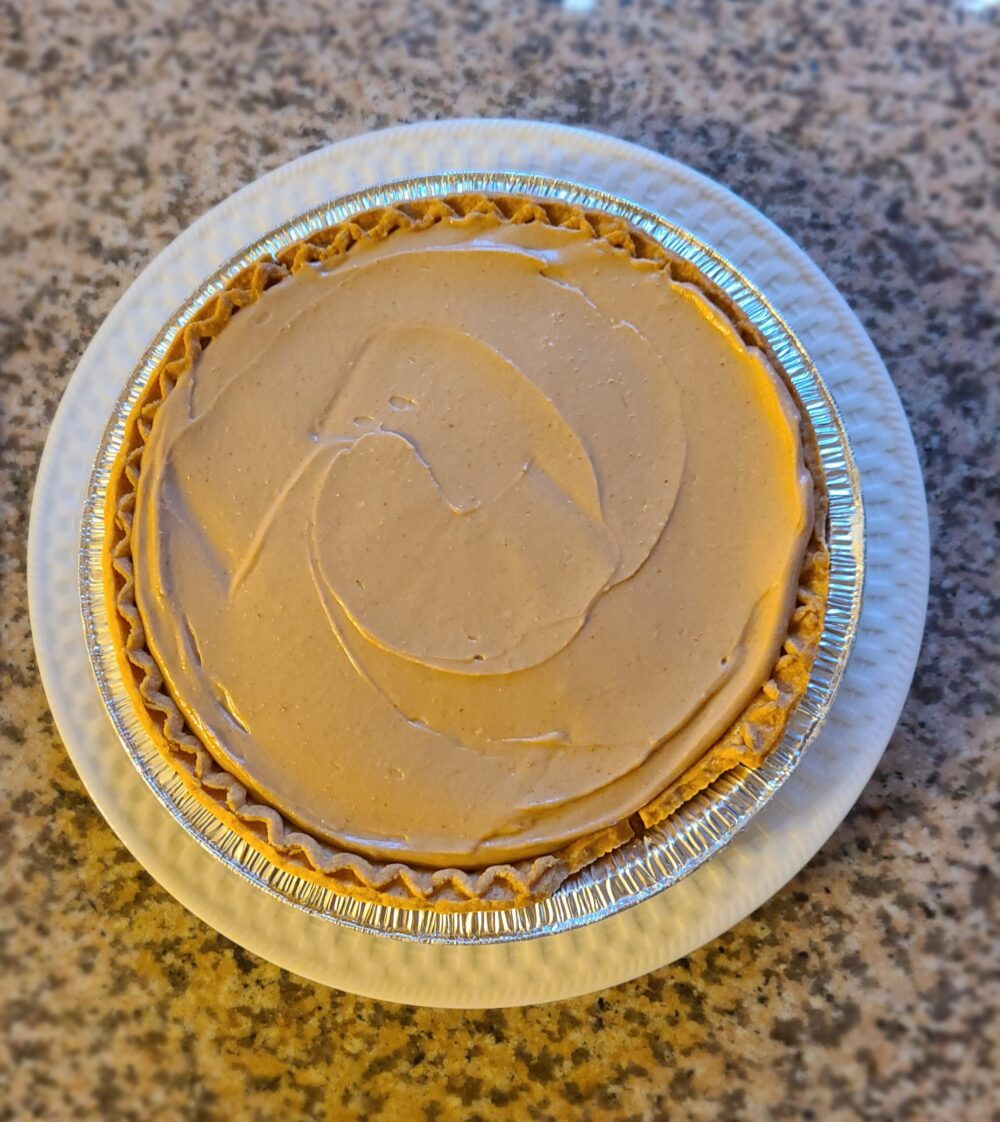 vegan chocolate peanut butter pretzel pie on a white plate against a marbled countertop