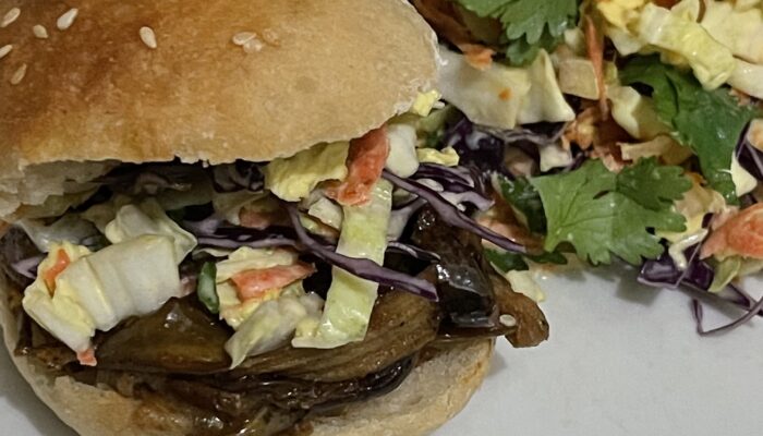 finished banana peel pulled pork slider with side salad on a white plate