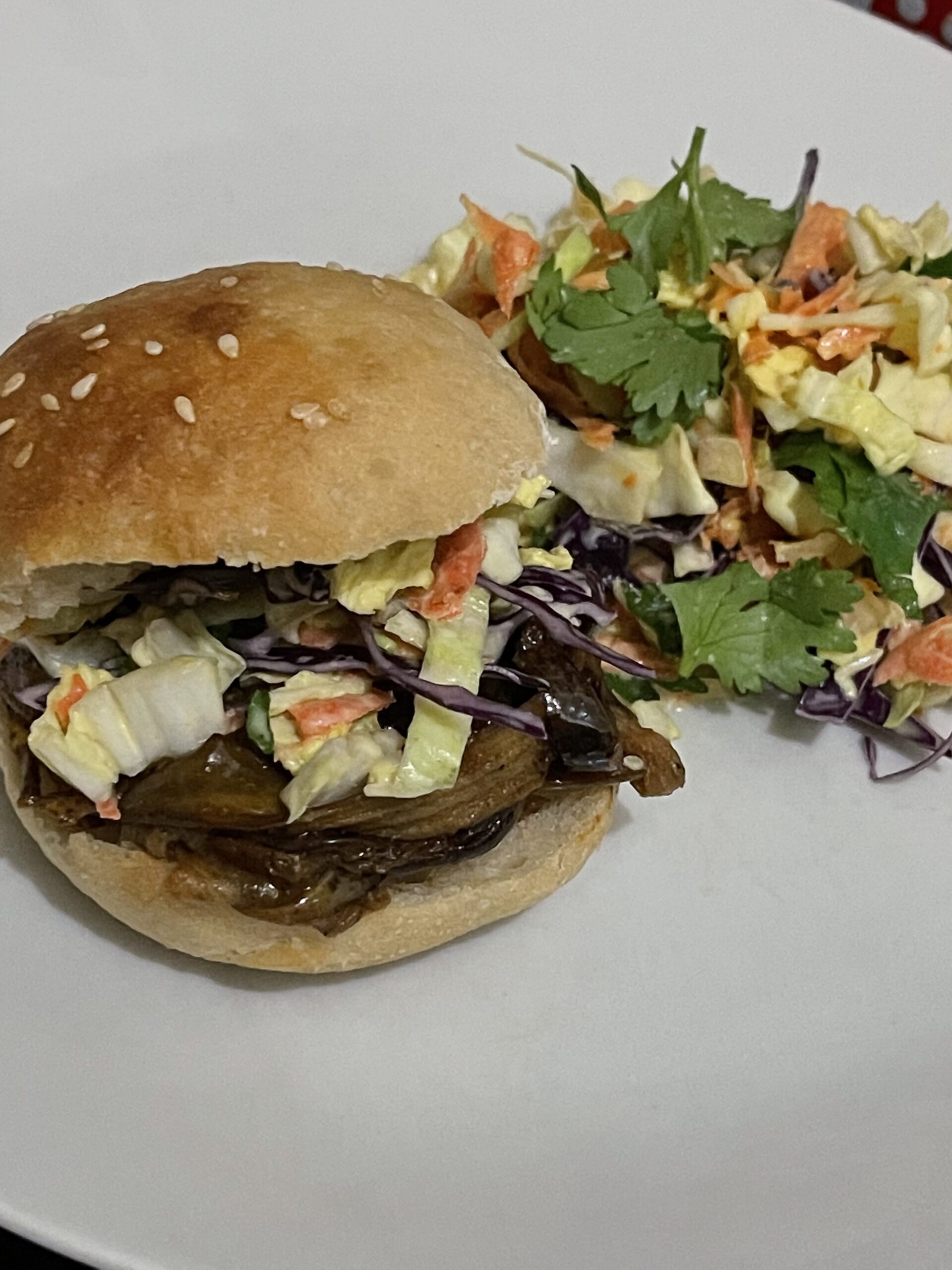 finished banana peel pulled pork slider with side salad on a white plate