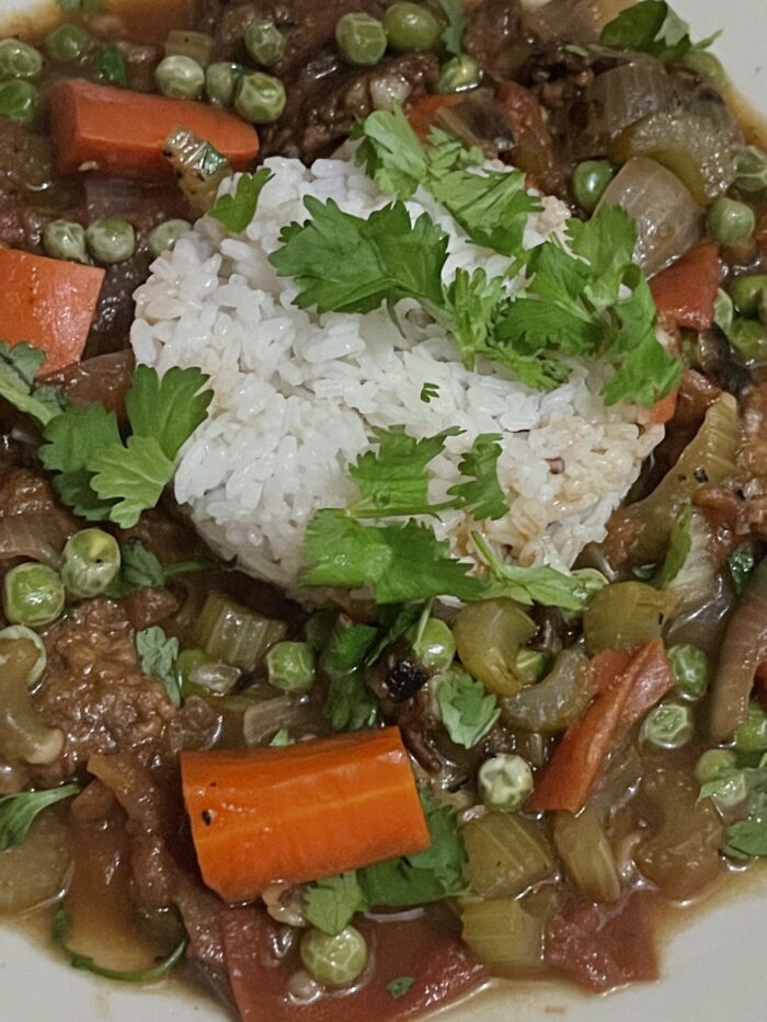 vegan beef stew with a scoop of white rice and a sprinkle of cilantro.