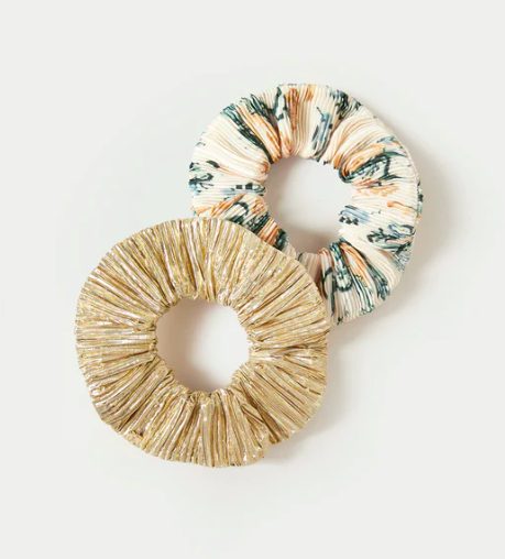 a gold lamé scrunchie and a floral scrunchie against a white background.