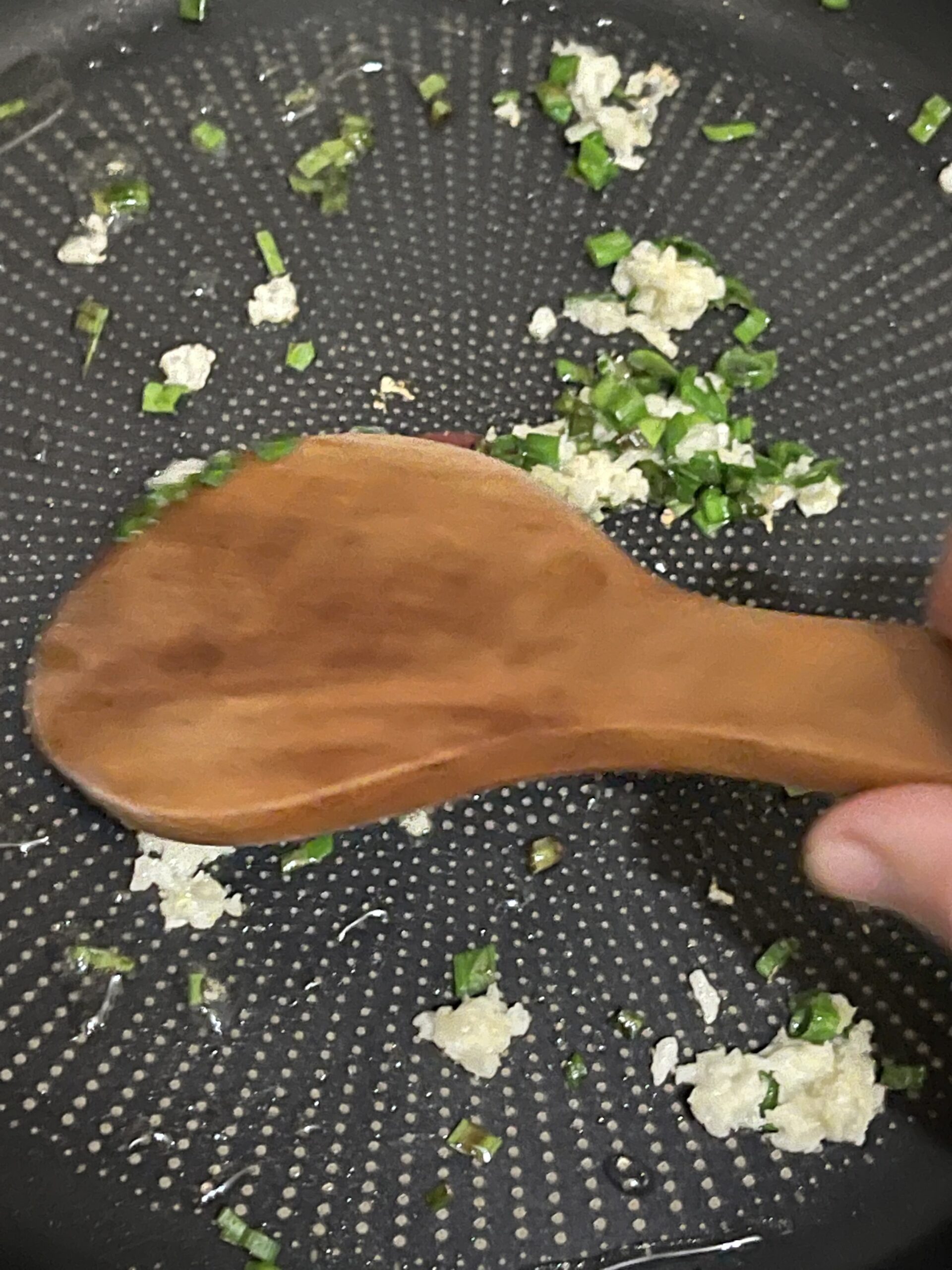 chopped green onions and garlic in an oiled pan