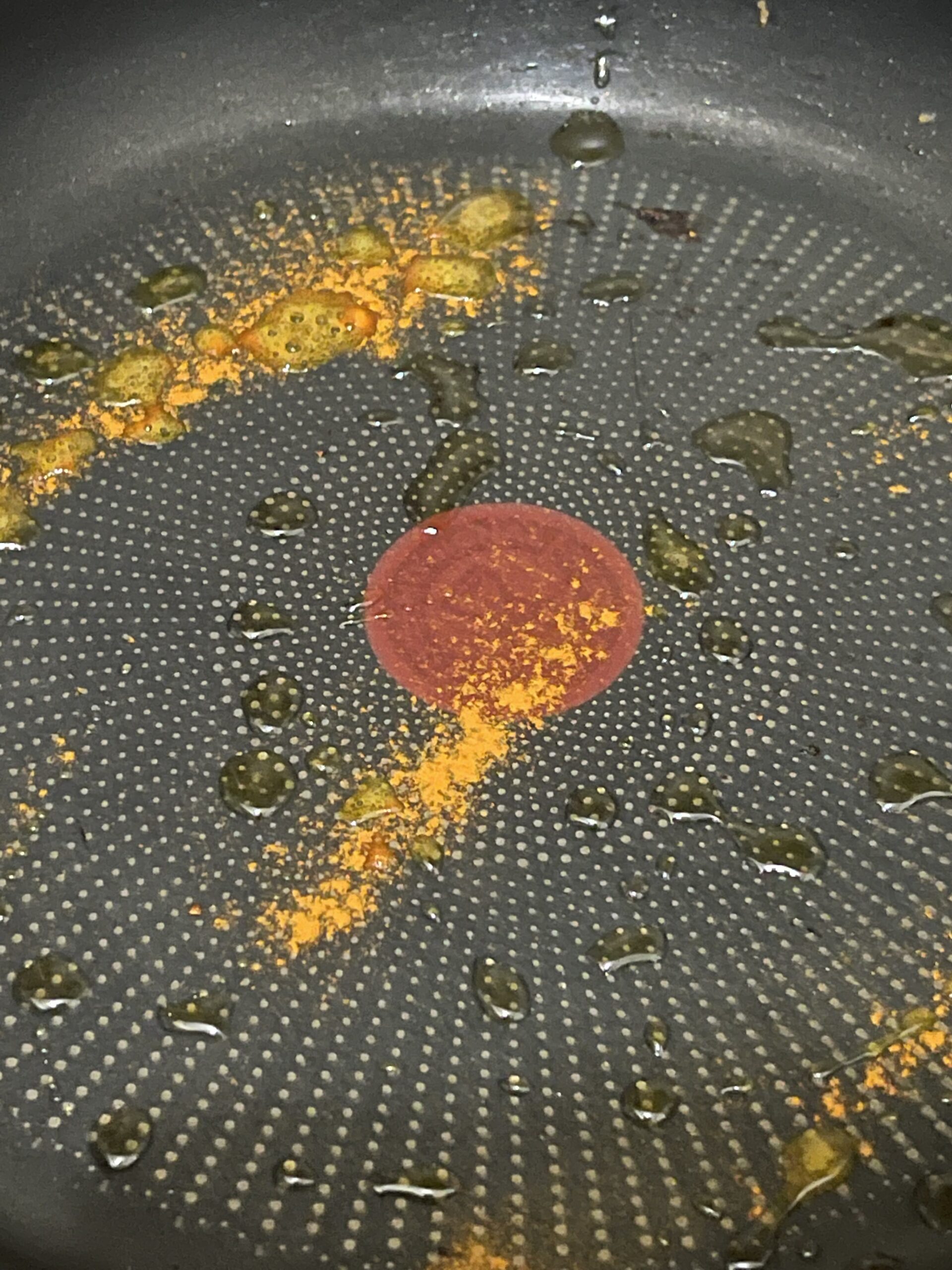 oiled pan with turmeric powder