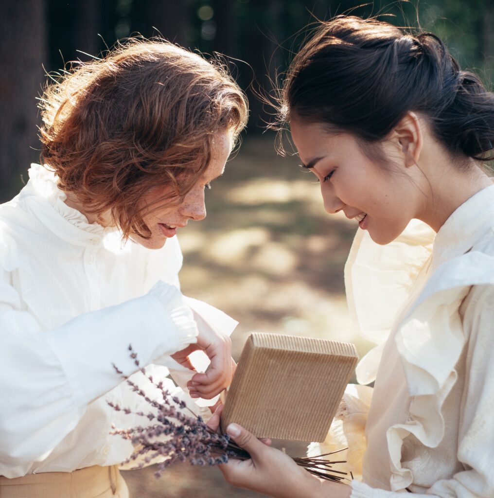 photo of two women sharing from a box