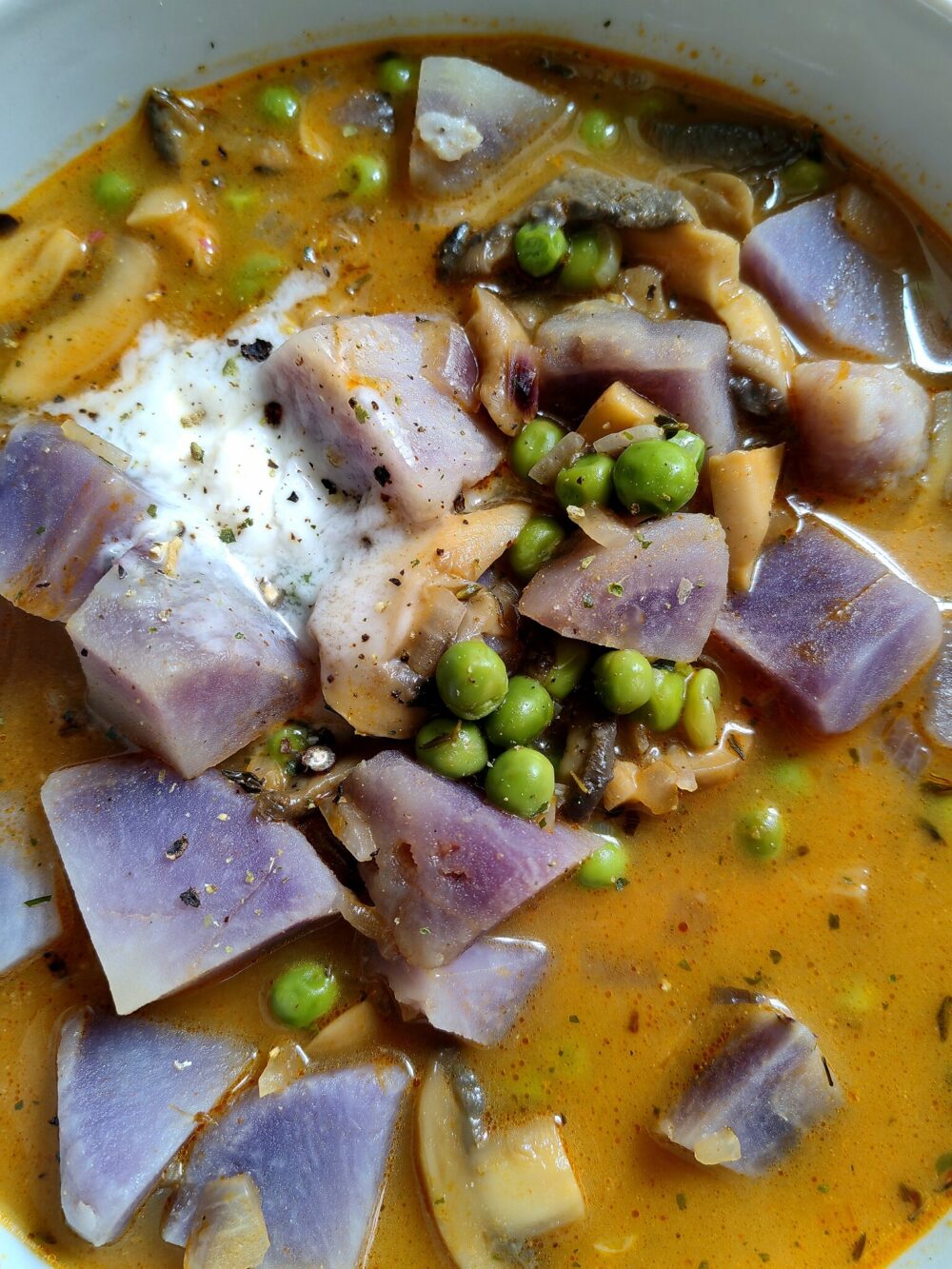 close up of vegan Peruvian soup garnished with vegan sour cream.