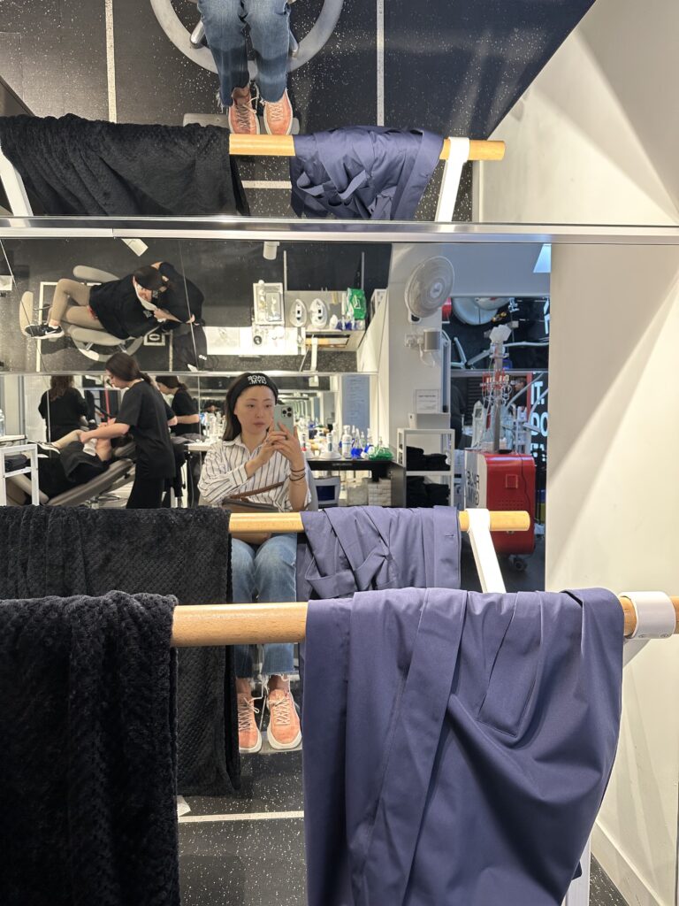 a woman client sitting on a chair and taking a selfie inside Face Gym