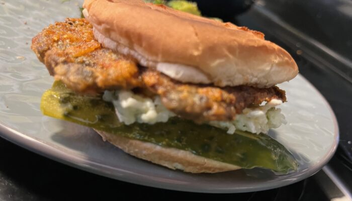 side view of vegan Nashville hot mushroom sandwich on a gray plate.