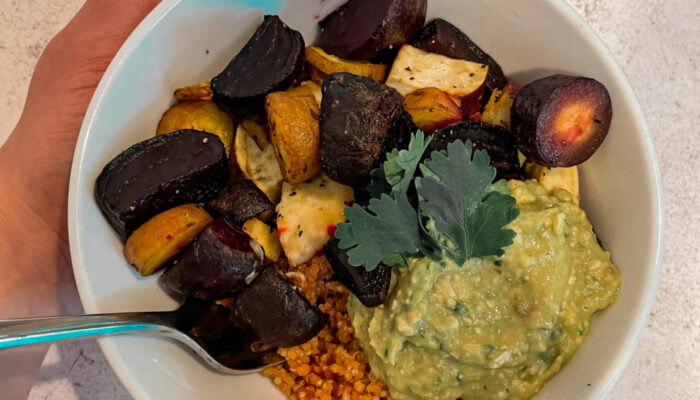 root veggie bowl with a hand holding it