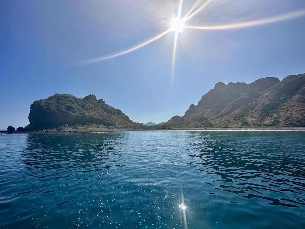 View of Loreto national park with the sun shining over an islet and the crystal clear blue waters.