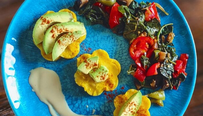 turmeric mashed potato shaped into flowers and placed artistically on a blue plate.