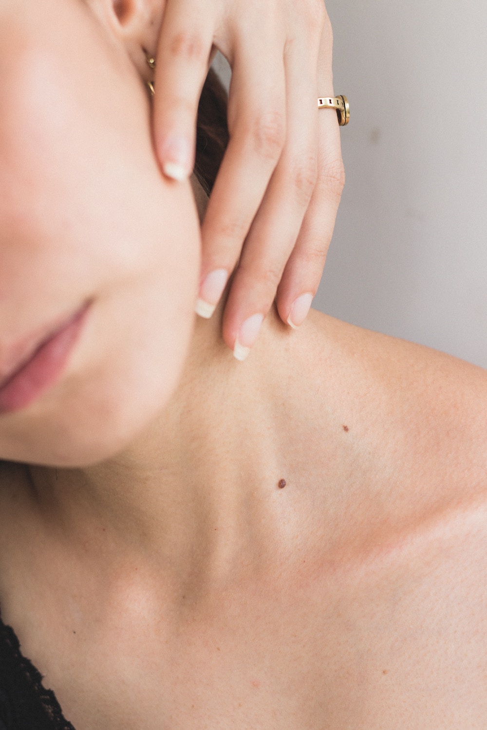 a close up of a woman caressing a side of her face with her hand