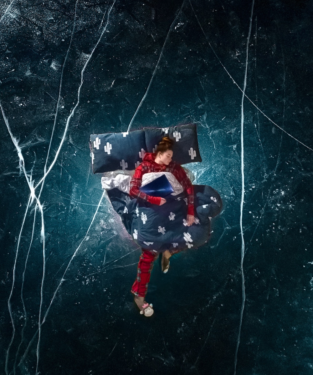 A woman in red long pajamas floating in the night sky, sleeping