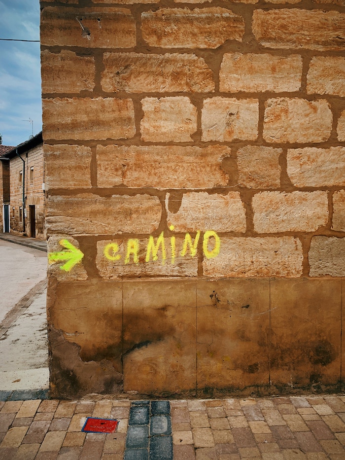 word camino and an arrow drawn on a brick wall. 